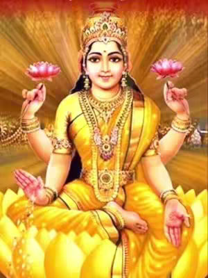 A digitally enhanced image of the Hindu goddess Lakshmi, sitting cross-legged on a large yellow lotus flower. She is adorned in golden jewelry, a crown, and a yellow sari. Her multiple arms and hands are in specific mudras. The background is a golden and reddish gradient.