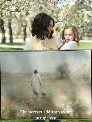 The cover image shows a woman holding a young child in front of a painting of Jesus. The woman and child are positioned in front of a backdrop of green grass and white blossoming trees, giving a sense of a peaceful setting.