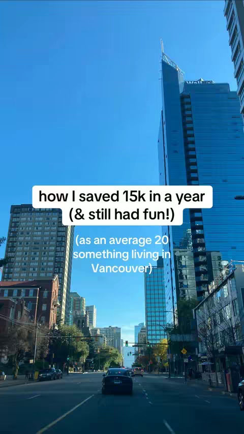 A daytime shot from a vehicle driving down a city street. The sky is bright blue, and tall buildings line the sides of the road, with trees and other structures visible. Text overlays near the top of the image feature the video's message, with a text box showing a white font.