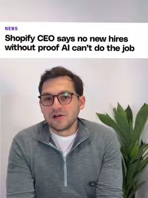 The cover image is a screen capture featuring a man in glasses and a button-up shirt looking directly at the camera and talking. Above his head, there's a white area with black text from a news source, including the word "NEWS". The background is simple, white, with a few green plants behind the speaker adding a touch of natural color. The overall composition is straightforward.