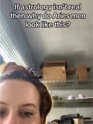 The image shows a close-up of a person's face, with only the forehead and eyes visible. Above, a text overlay poses a question about astrology and Aries men. The background has shelves with various items on them. The overall composition is centered on the facial expression with a focus on the eyes, using soft lighting that appears natural.