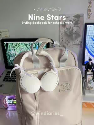 The image showcases a beige backpack with white headphones. The backpack is the focal point, set against a backdrop of a laptop screen displaying a blurred nature scene, a shelf with decorative elements, and a wall with Japanese text and a framed picture. The composition is balanced, with soft lighting and a focus on the products, creating a clean and modern aesthetic.