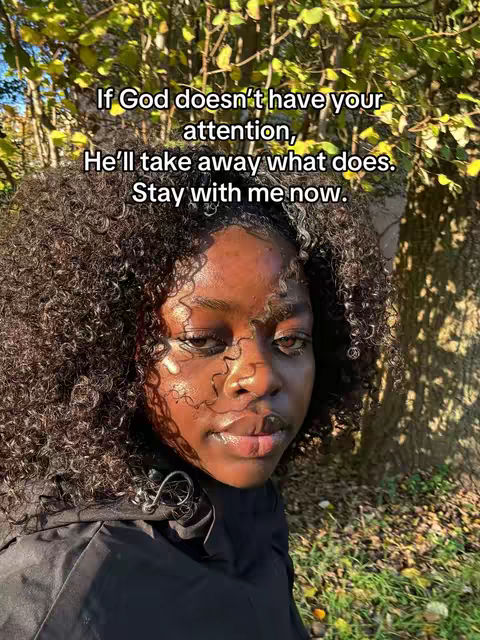 The image shows a close-up of a person's face with curly hair; text overlay adds a message; the background has out-of-focus foliage.