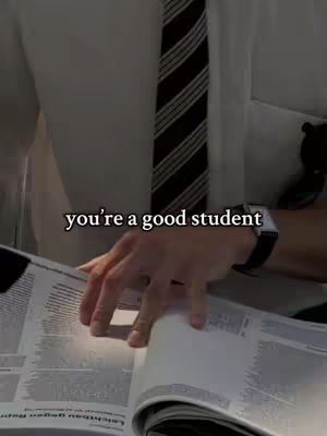 A close-up shot focuses on the upper body of a person wearing a white shirt and a striped tie. The person's hand is visible, turning the pages of an open book or document, with text on the pages. The background is slightly blurred, with the text overlayed with the phrase: 'you're a good student'.