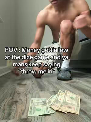 A man, shirtless, kneels on a wooden floor with a few scattered dollar bills. Text overlayed reads "POV: Money gettin low at the dice game and ya mans keep saying 'throw me in'".