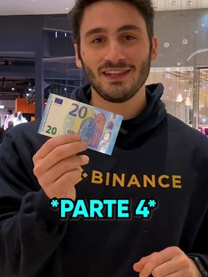 A man is holding a 20 Euro bill in front of his chest. He wears a black hoodie with the Binance logo on it, and there is text overlayed with the words "PARTE 4" in a blue and green font. The image is shot in a well-lit indoor location, likely a store or public space, as indicated by the out-of-focus background.