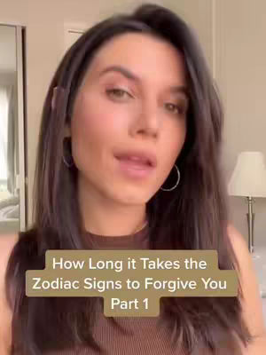 A woman with long dark hair, wearing a brown top, is the focus of the image. The background includes a mirror and parts of a room setup. A text box at the bottom says, "How Long it Takes the Zodiac Signs to Forgive You Part 1".