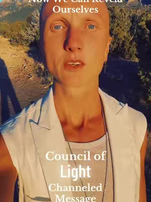 A person with short, light hair and fair skin looks directly at the camera. They are wearing a white, sleeveless vest over a white tank top, with a silver chain necklace. The background shows a blurred outdoor scene with trees and sunlight. Text overlays read 'Now We Can Reveal Ourselves' at the top and 'Council of Light Channeled Message' at the bottom.