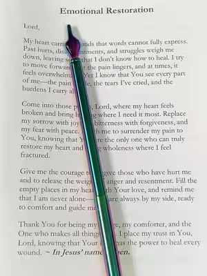 The cover image features a handwritten prayer or writing positioned on top of a book page. An ornate, iridescent pen rests diagonally across the page, emphasizing the act of writing and spirituality.