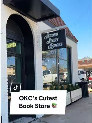 The image shows a storefront with a black awning. A sign on a metal frame reads "Second Story Books". Below this, a white box overlays the image with the words "OKC's Cutest Book Store". A TikTok logo is visible in the left corner.