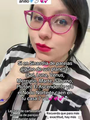 A woman with pink-framed glasses and red lipstick looks at the camera, hand up with a ring. Text overlay explains the astrological concept of "sinastria", while text describes in more detail and additional icons are over the image.