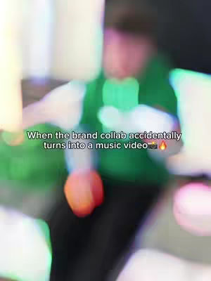 The image is a blurred, abstract shot with a mix of green, white, and red colors. The layout appears to have multiple layers of out-of-focus elements, making it hard to discern specific details, and text overlays the image.