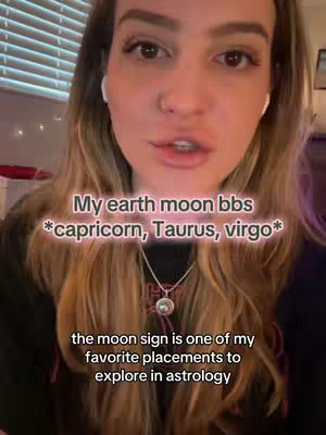 A woman with long brown hair and white earbuds speaks to the camera. The background shows a window with blinds. Text overlays read, 'My earth moon bbs *capricorn, Taurus, virgo*' and 'the moon sign is one of my favorite placements to explore in astrology'.