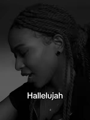 A black and white image of a woman with braided hair, looking down and to her left. She is wearing a dark top and a necklace. Text overlayed at the bottom reads 'Hallelujah'. The image has a close-up focus on her face.