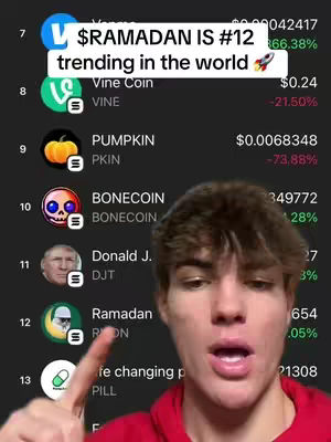 A young man with short brown hair is pointing at a screen displaying a list of cryptocurrency tokens. A text overlay at the top reads '$RAMADAN IS #12 trending in the world,' and the man's face takes up the foreground. The list shows various tokens with their symbols and current values.