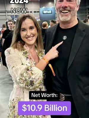 The cover image features a smiling woman and a man with a Bitcoin logo. The caption appears in white, bold text. It is set over a background of a gathering, perhaps conference or event.