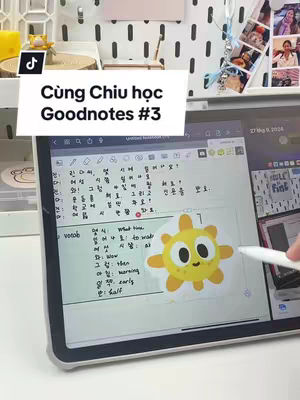 The image shows a close-up of an iPad displaying a Goodnotes note, with a white overlay box containing the Vietnamese text “Cùng Chiu học Goodnotes #3.” A yellow cartoon sun sticker with text is on the note. Partially visible in the upper right is a wall-mounted organizer with photos and accessories. A hand holding a white stylus points towards the screen.