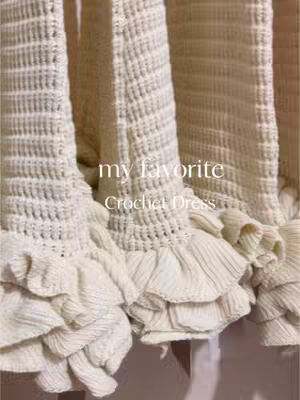 The cover image showcases a close-up view of a cream-colored crochet dress. The dress features intricate crochet patterns, particularly in the skirt area with a ruffled hem. The text "my favorite Crochet Dress" is overlaid in a clean, sans-serif font. The color palette is primarily neutral with warm tones, and the lighting appears soft and diffused.