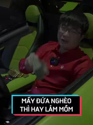 A man in a red shirt is sitting in the front seat of a flashy car with light green seat details, seemingly talking and gesturing. A text overlay reads in Vietnamese.
