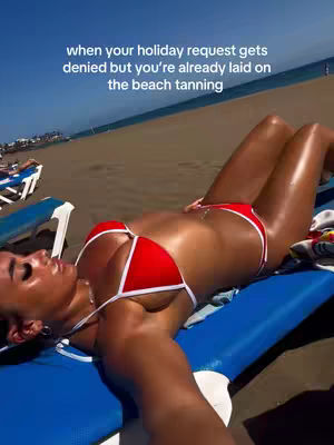 A woman in a red bikini lies on a blue beach chair, with a beach and blue sky in the background. The woman is tanned and the image has a bright, summery feel.