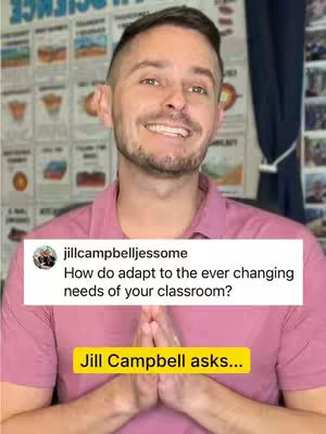 A man with short brown hair and a beard is holding hands together in front of his chest, smiling into the camera. He is wearing a light pink shirt. Behind him is a somewhat blurry background that appears to be a classroom with posters and a whiteboard. There is a white box superimposed on the image containing text. A yellow box underneath the text says "Jill Campbell asks..."