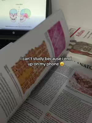 A person is studying, with a book open in the lower portion of the image and their laptop showing images on screen; a text overlay explains they can't study because they are always on their phone.