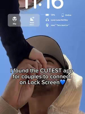 A close-up shot showing a person holding the phone with the lock screen displayed. The lock screen has a clock, battery, and music information. The foreground features the person's face and an arm.