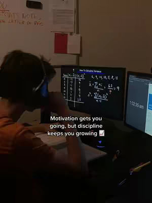 A person is seated at a desk, working on a computer. A computer screen shows a math problem. Text on the screen reads "How to calculate variance". On the right, there is a second computer screen with a time of "1:02.35 am". The person is facing away from the camera and wearing headphones.