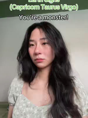 A woman with long black hair is centered in the frame. The top part of the image has green text: Earth signs (Capricorn Taurus Virgo), and below the woman's head is more white text: You're a monster!