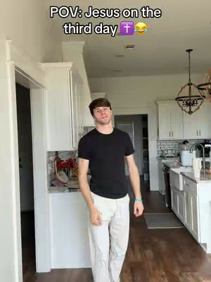 A man is standing in a kitchen, with written text overlayed at the top of the image. A door is on the left, and white cabinetry spans the top of the image.
