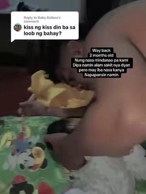 A person is holding a baby, the baby is holding a plush toy. A comment and a reply text also appear on the screen.