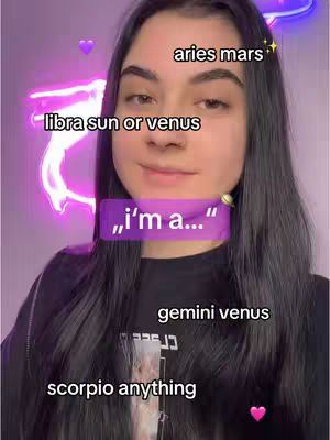 A selfie-style image of a young woman with long black hair, centered in the frame. She smiles slightly, and the background features a neon light design in purple. Overlay text with astrology terms such as 'aries mars', 'libra sun or venus', 'gemini venus', and 'scorpio anything' are placed around the woman's head. Pink heart emojis enhance the visual composition.