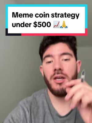 A man in a grey shirt is centered in the frame, with a turquoise and magenta bar at the top containing the text 'Meme coin strategy under $500' in white. The man has a beard and is holding a pen.