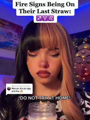 A young woman with two-toned hair (black on the left, blonde on the right) is centered in a vertical shot. She has a light complexion, dark eye makeup, and deep red lipstick. The background is dark with a colorful painting on the left and what appears to be a decorated lamp. Text overlays include two lines at the top and bottom, and a comment section with some text on the bottom left of the image.