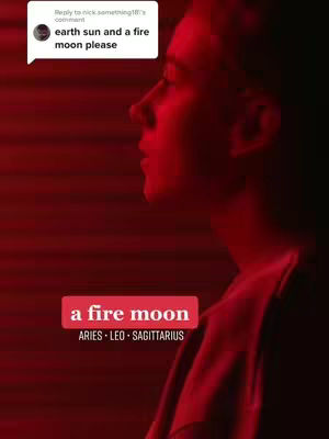 A profile shot of a man with his face in profile, illuminated by a red glow. The background is a gradient of red, and there's a text overlay with the phrase 'a fire moon' along with the associated zodiac signs. A speech bubble in the top left corner indicates a comment.