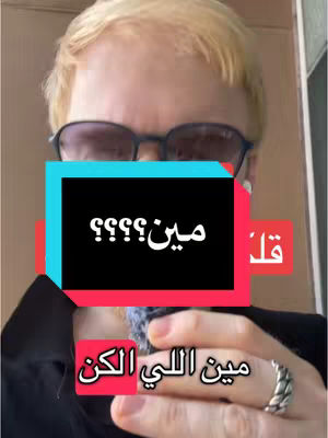 A selfie-style shot featuring a fair-skinned person with light blonde hair, wearing glasses, and a dark shirt. Overlaid on the image are text boxes in various colors with text in Arabic script The person is positioned in the center of the frame, with the text covering parts of their face.