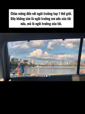 The cover image captures a scene from inside a vehicle, looking out a window. The view showcases a body of water with a cityscape in the distance, marked by tall buildings and a cloudy sky. Within the frame, a person is riding a bicycle, captured in motion. The upper portion of the image displays an overlaid text in Vietnamese.
