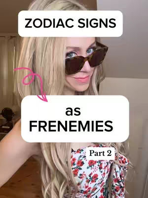 A light-skinned woman with long blonde hair and sunglasses, wearing a floral top, is the primary focus. Text boxes overlay, reading 'ZODIAC SIGNS' and 'as FRENEMIES' with a pink arrow directing to the bottom text. The background is an indistinct interior lit by warm light, suggesting a casual setting.