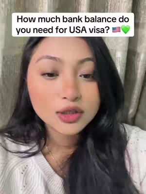 A woman with dark hair and fair skin is the focus. She is positioned centrally, looking towards the viewer with a neutral expression. The background suggests an indoor setting, with a curtain. A text overlay at the image's top poses a question about bank balance for a USA visa.