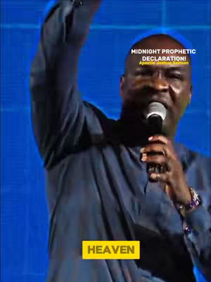 The image shows a man speaking into a microphone, his arm raised. Text overlays say "MIDNIGHT PROPHETIC DECLARATION!" and "HEAVEN". The background is a gradient of blue hues.