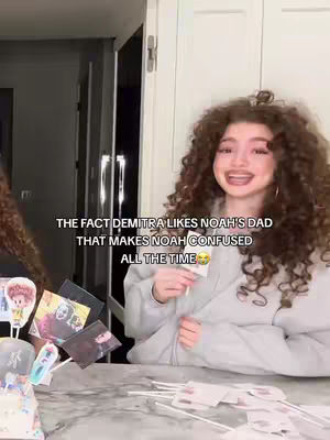 The cover image shows a young woman with curly brown hair in a gray hoodie, holding a small white card. The text overlay indicates she is talking about a situation involving someone's dad. Various images and sticks are in front of her. The background appears to be a domestic setting with a visible door and a portion of another person on the left.