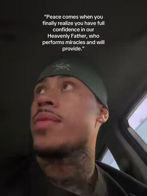 A man is shown from the chest up, looking upward and to the side, with text overlaid: 'Peace comes when you finally realize you have full confidence in our Heavenly Father, who performs miracles and will provide.' He has a green cap, goatee, and noticeable neck tattoos. The background is dark, suggesting he is inside a vehicle.
