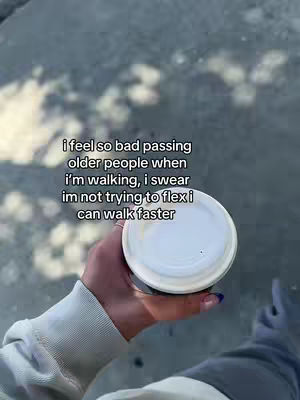 A person's hand holding a white coffee cup with a lid, with text overlayed and blurry background.