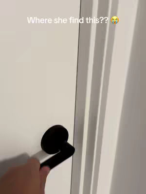 The image shows a close-up of a white door and a black door handle. A hand is reaching towards the handle, as if about to open the door. The text overlay at the top of the image says, "Where she find this??" with a surprised emoji.