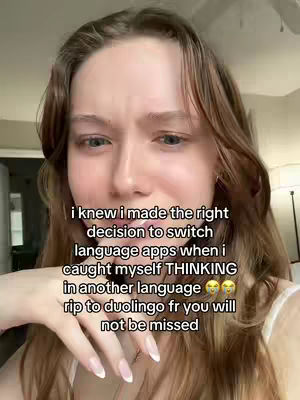A young woman with long brown hair is centered in the frame, looking directly at the camera. The background is slightly blurred, showing interior details like walls. The overlay text is in a white, easy-to-read font.