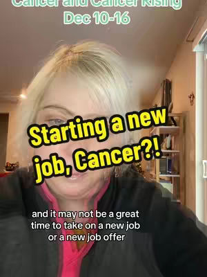 A woman with blonde hair is centered in the shot, looking at the camera with a slight smile. The background includes interior elements like shelves and a window, suggesting a home environment, creating the impression of a casual video.