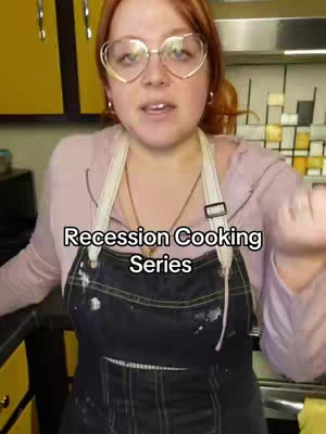 The cover image shows a woman in a kitchen setting, facing the camera. She has red hair and is wearing heart-shaped glasses. She's wearing a light pink top and a black apron with white paint marks. The text overlay reads 'Recession Cooking Series'. The background includes cabinets and kitchen equipment.