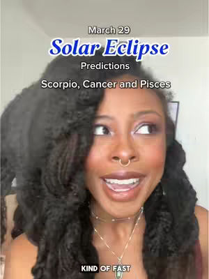 A woman with dark curly hair smiles at the camera with text overlayed at the top. The text says "March 29 Solar Eclipse Predictions". The woman has a nose ring and is wearing necklaces. The background has a light colored wall with a blurry image in background. The bottom of the image contains "KIND OF FAST".