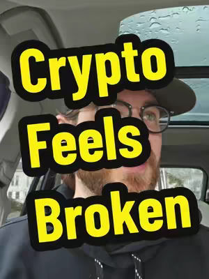 The cover image shows a man in a car, wearing a cap and glasses, with overlaid text in a yellow and black design. The text states "Crypto Feels Broken" against a backdrop of a car interior. Rain is visible on the window.
