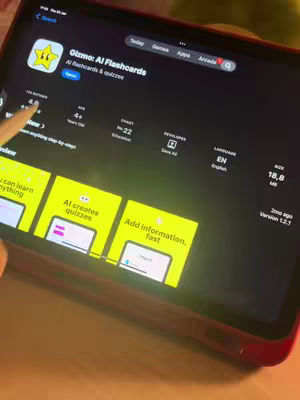The cover image shows an iPad displaying the App Store page for 'Gizmo: AI Flashcards.' The screen is mostly dark, with the app icon, name, and description taking prominence. The top of the screen shows typical iOS status bar elements, and a pencil is visible, suggesting user interaction. The background is a neutral color, providing a clean setting.